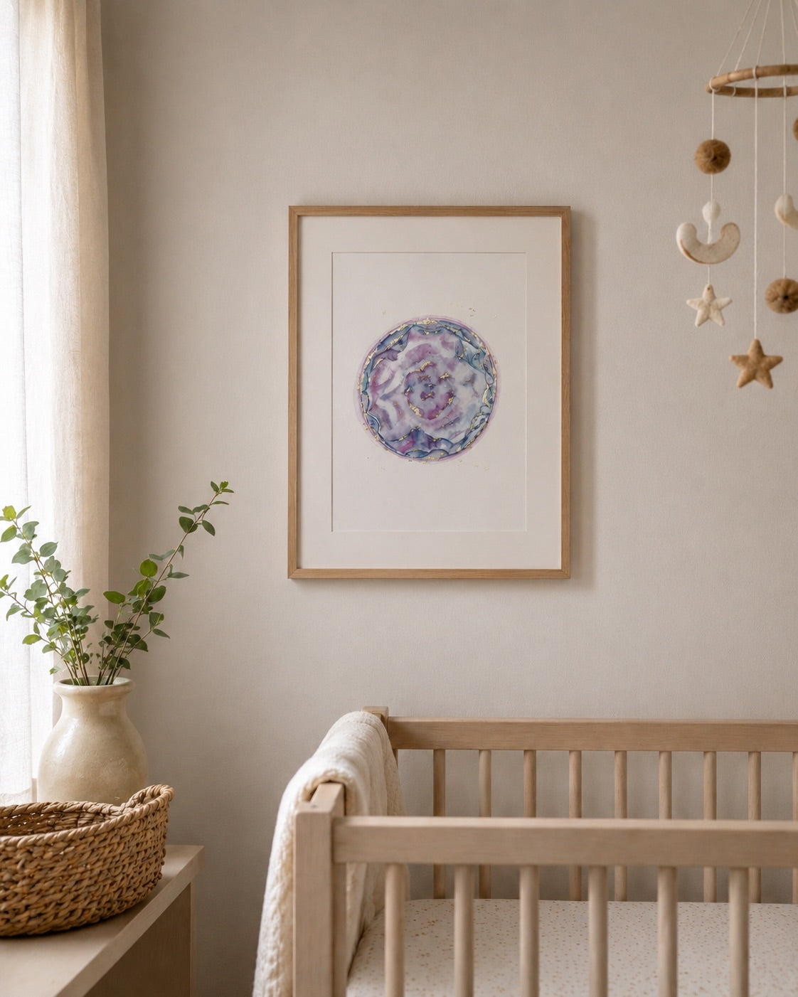 Nursery room with a framed watercolour embryo, crib, and decorative items.
